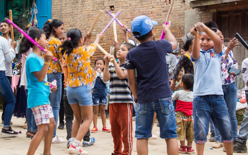 Children beating in rhythm with wooden sticks during Gai Jatra.jpg