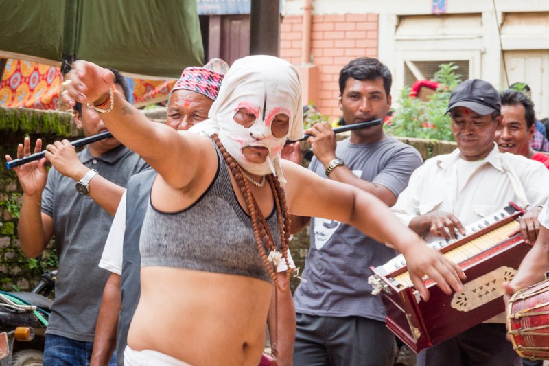 Costumed man dancing in front of musicians.jpg