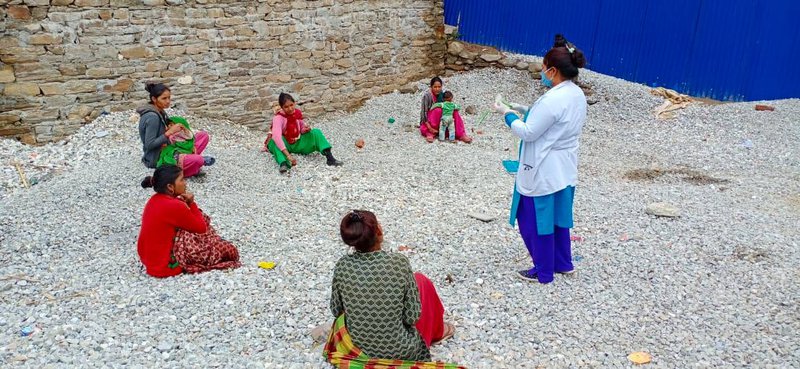 Health worker in Khadachakra of Kalikot District provides necessary instruction to the mothers of children to carry out family MUAC at home while maintaining social....jpg