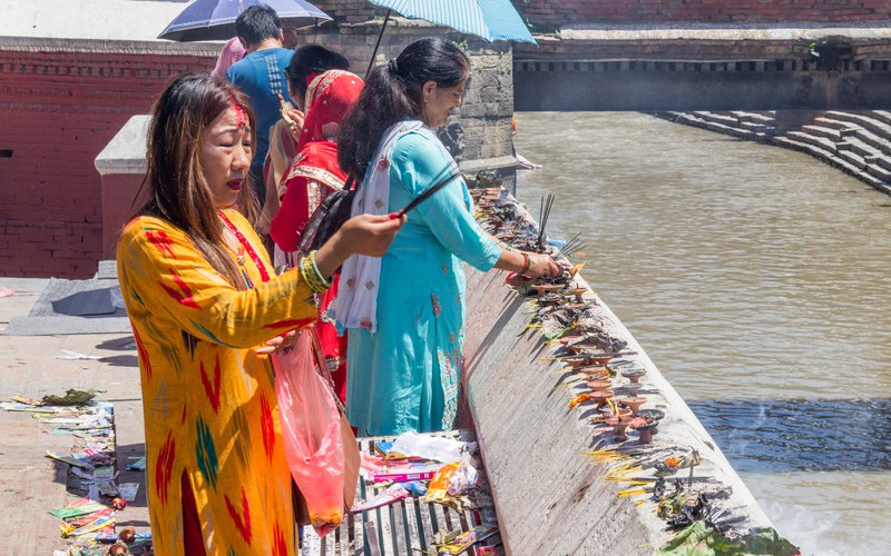 Women praying next to Pashupatinath temple duing Sharwan Monday festival.jpg